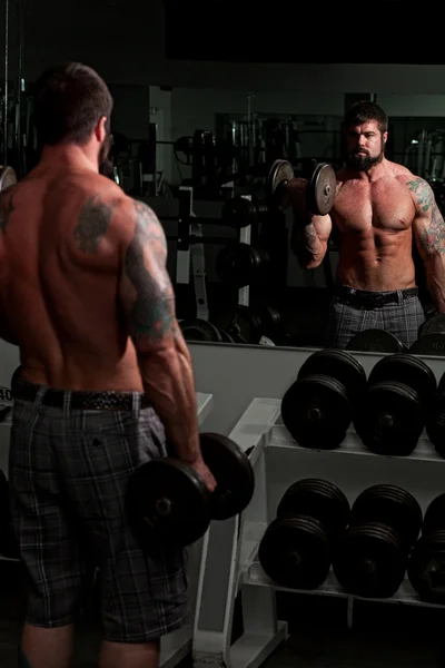 Bodybuilder masculin travaillant dans une salle de gym . — Photo