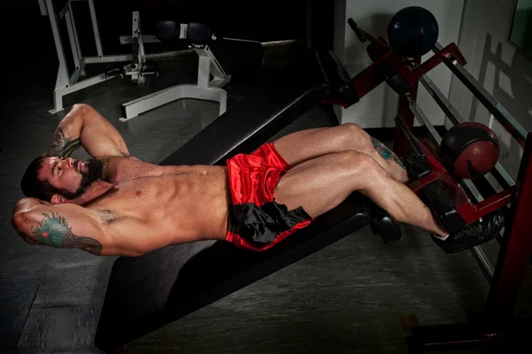Construtor de corpo masculino trabalhando em um ginásio . — Fotografia de Stock
