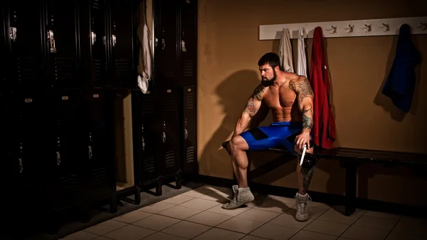 Muskulöser Wrestler in der Umkleidekabine vor oder nach einem Match. — Stockfoto