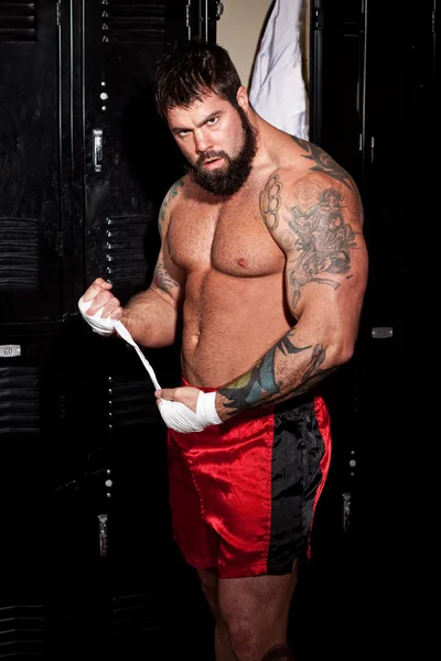 Muscular fighter in a locker room before or after a match. — Stock Photo, Image