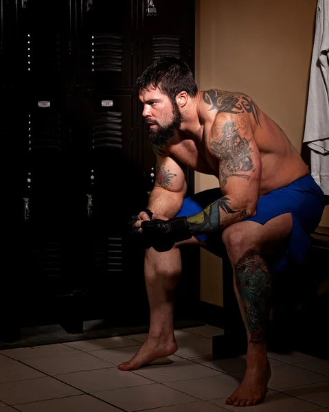 Muskulös fighter i ett omklädningsrum före eller efter en match. — Stockfoto