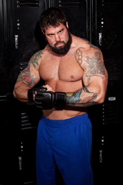 Muskulös fighter i ett omklädningsrum före eller efter en match. — Stockfoto