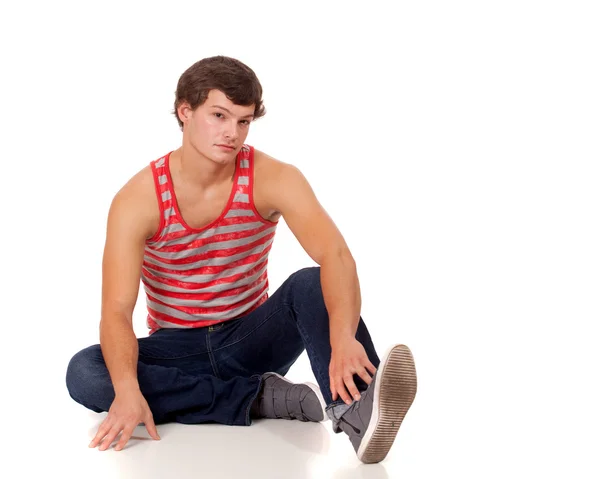 Молодой человек в красно-белой полосатой рубашке и джинсах . — стоковое фото
