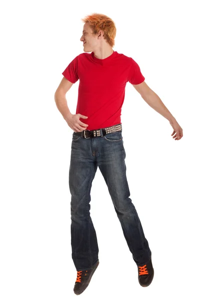 Ung man i en röd tröja och jeans. Studio skott över vita. — Stockfoto