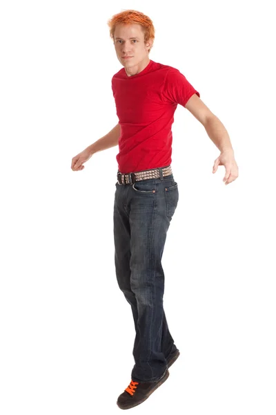 Jonge man in een rode shirt en spijkerbroek. studio opname over Wit. — Stockfoto