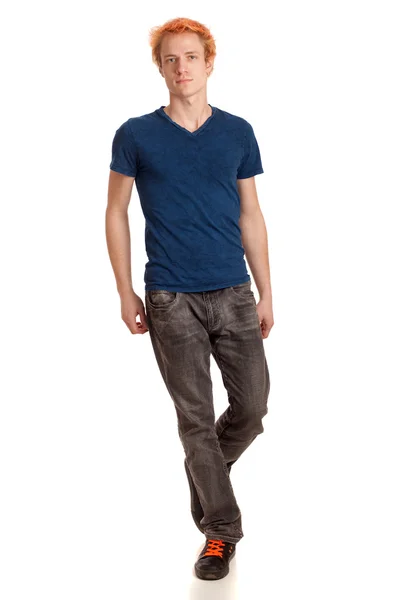 Молодой человек в синей рубашке и джинсах. Студия над белым . — стоковое фото