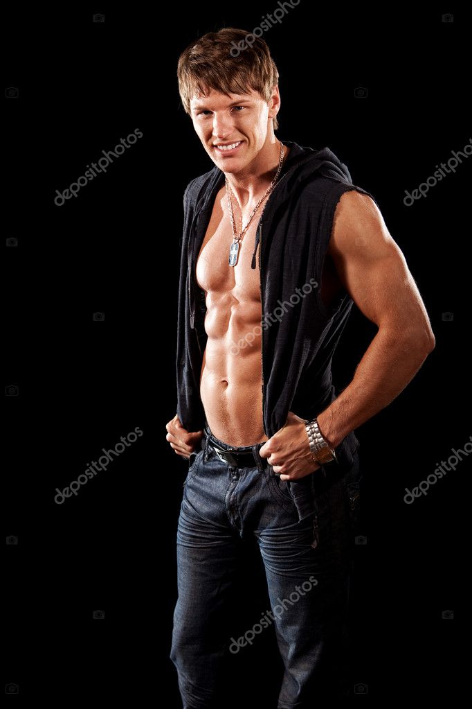 Bodybuilder in jeans with shirt open. Studio shot over black. Stock ...