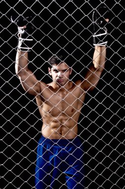 Mixed martial artist posed behind chain link clipart