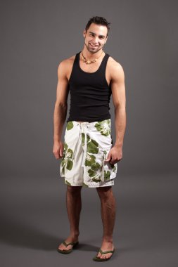 boardshorts çekici genç adam. Stüdyo gri vurdu.