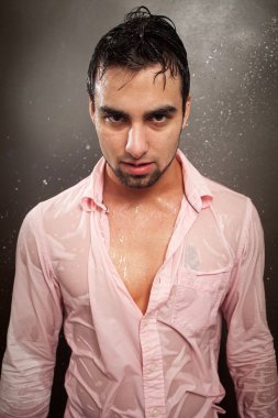 Young man in a soaking wet pink button down shirt. clipart