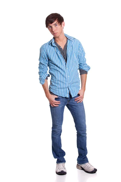 Ung man i blå jeans och skjorta. Studio skott över vita. — Stockfoto