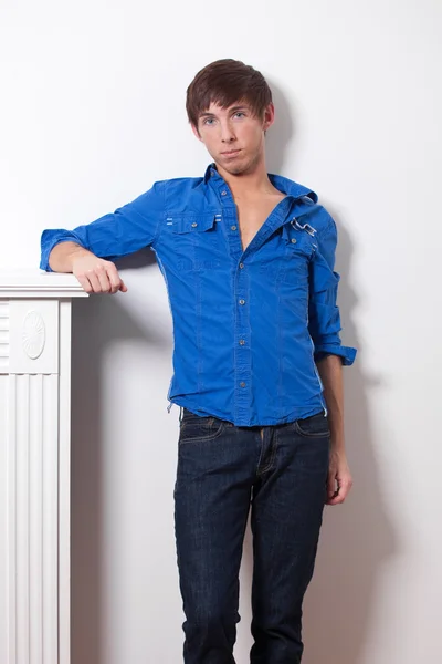 Junges erwachsenes männliches Modell in blauem Hemd und Jeans. — Stockfoto