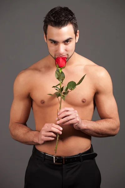 Aantrekkelijke man shirtless met een enkele rode roos. — Stockfoto