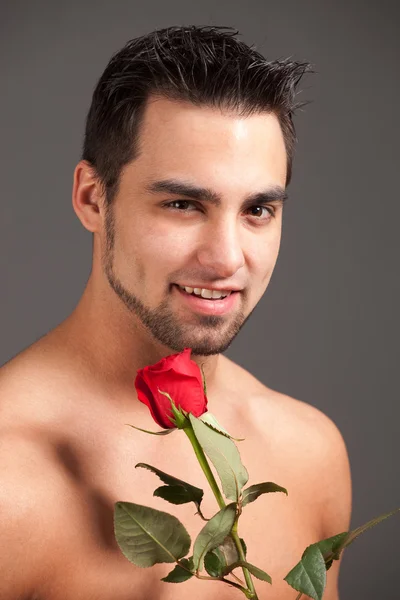 Hombre atractivo sin camisa con una sola rosa roja . — Foto de Stock