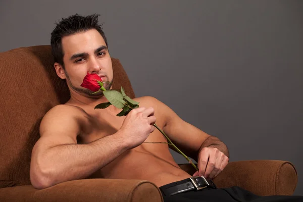 Atraktivní muž košili s jedinou rudou růži. — Stock fotografie