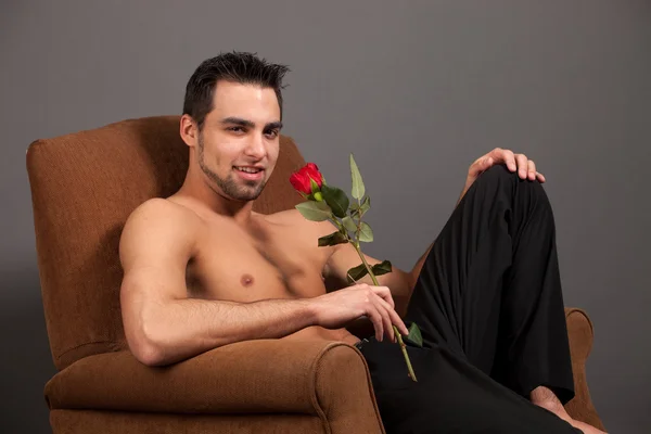 Привлекательный мужчина без рубашки с одной красной розой . — стоковое фото