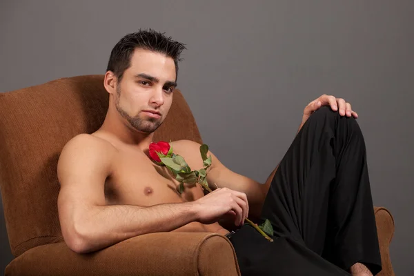 Привабливий чоловік без сорочки з єдиною червоною трояндою . — стокове фото
