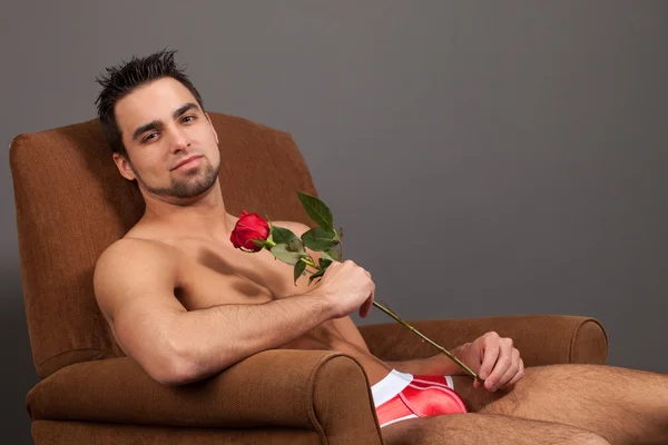 Homme attrayant en sous-vêtements avec une seule rose rouge . — Photo