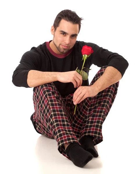 Attraktiver Mann im Schlafanzug mit einer einzigen roten Rose. — Stockfoto