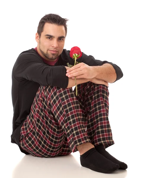 Attractive man in pajamas with a single red rose. — Stock Photo, Image