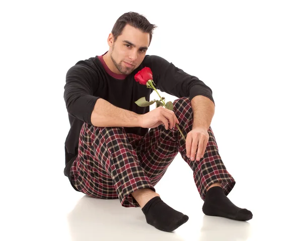 Attractive man in pajamas with a single red rose. — Stock Photo, Image