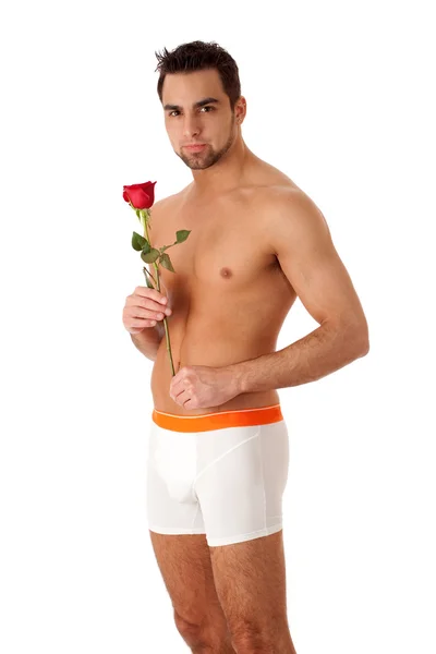 Attraktiv man i underkläder med en enkel röd ros. — Stockfoto