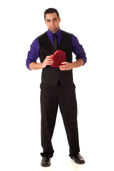 Välklädd ung man med en hjärtformad låda. — Stockfoto