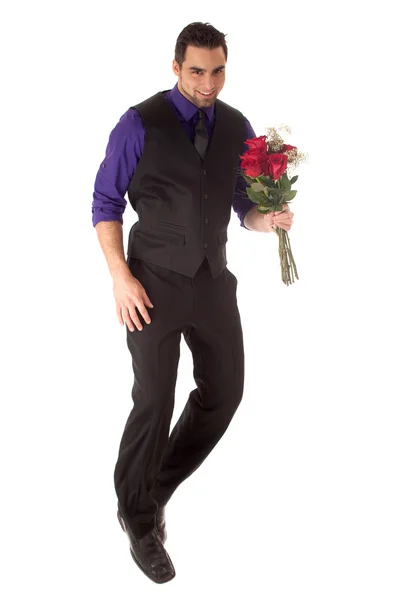 Goed geklede jonge man met een dozijn rode rozen. — Stockfoto
