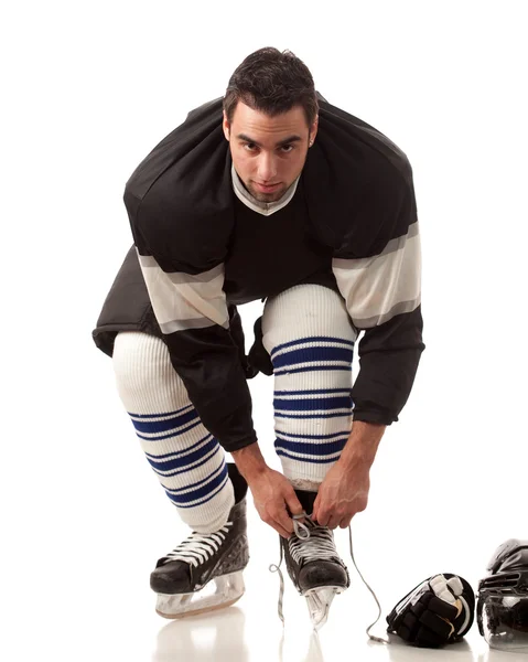 Ice hockey player dressing. Studio shot over white. — Stock Photo, Image
