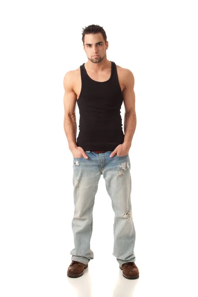 Junger Mann in Jeans und schwarzem Unterhemd. Studioaufnahme über Weiß. — Stockfoto