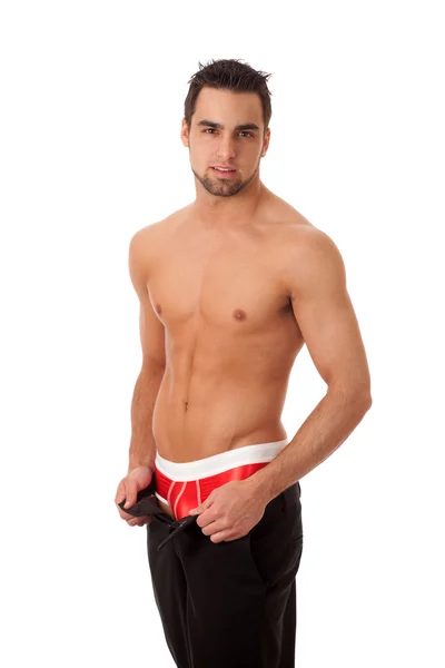 Homem atraente com calças desapertadas, mostrando roupa interior vermelha. Estúdio disparado — Fotografia de Stock