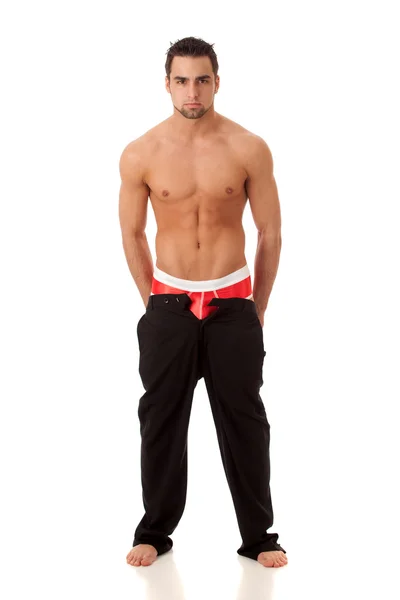 Привабливий чоловік з штанами розпакований, показує червону нижню білизну. Студійний знімок завершено — стокове фото