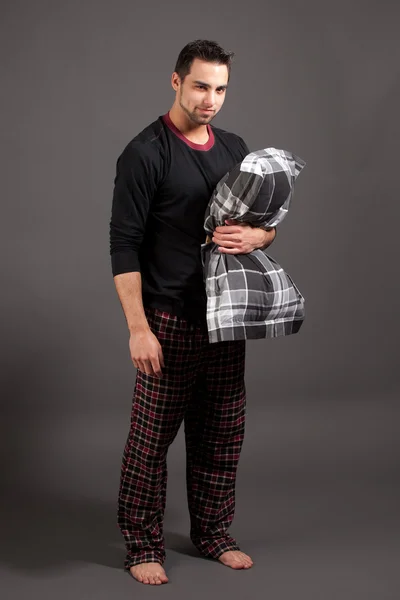 Um homem atraente de pijama. Estúdio filmado sobre cinza . — Fotografia de Stock