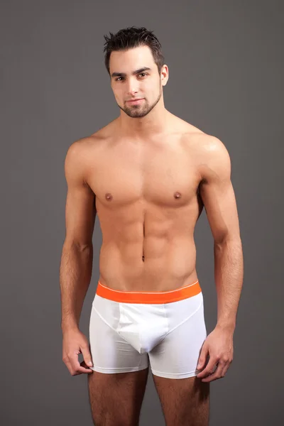 Attractive man in underwear. Studio shot over grey. — Stock Photo, Image