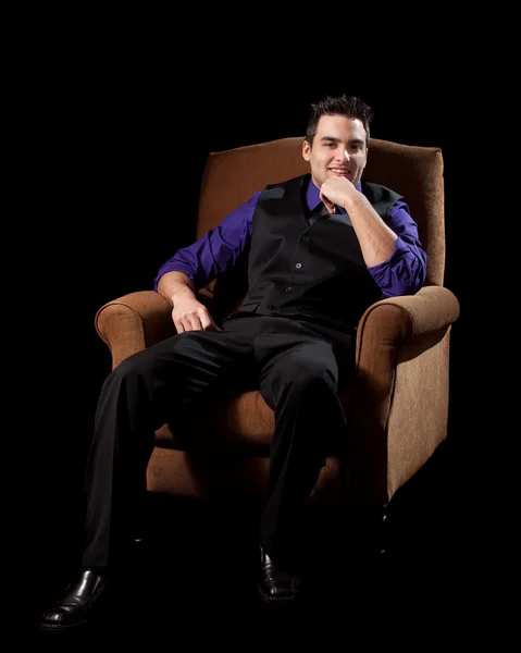 Un uomo ben vestito sulla sedia. Studio girato sopra nero . — Foto Stock