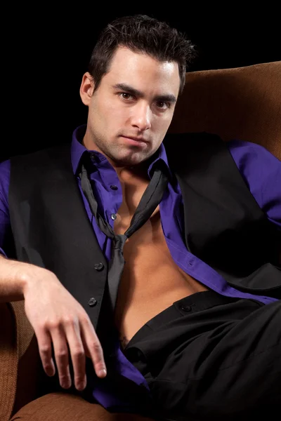 Gut gekleideter Mann im Stuhl, Hemd offen. Studioaufnahme über Schwarz. — Stockfoto