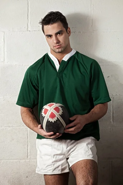 Male rugby player in front of concrete block wall. — Stock Photo, Image