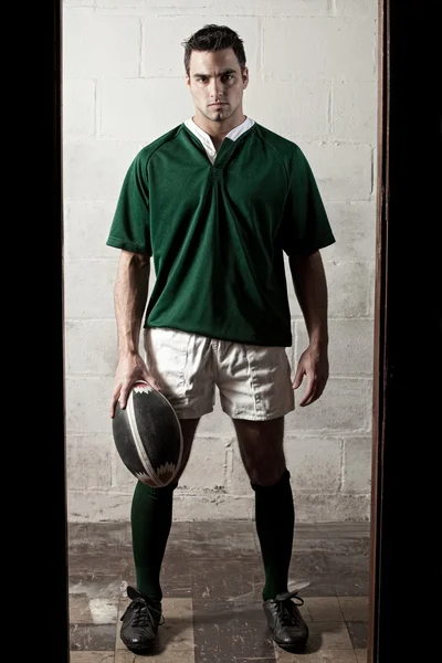 Jugador de rugby masculino en frente de la pared de bloque de hormigón . — Foto de Stock