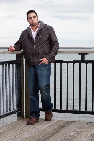 Man in jeans and leather jacket near water. — Stock Photo, Image