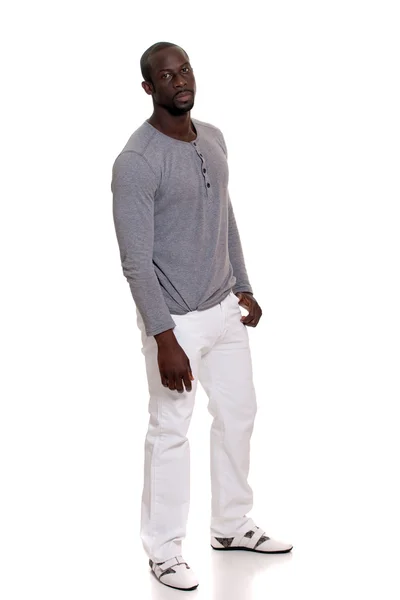 グレーのシャツと白いズボンの男。白にわたって撮影スタジオ. — ストック写真