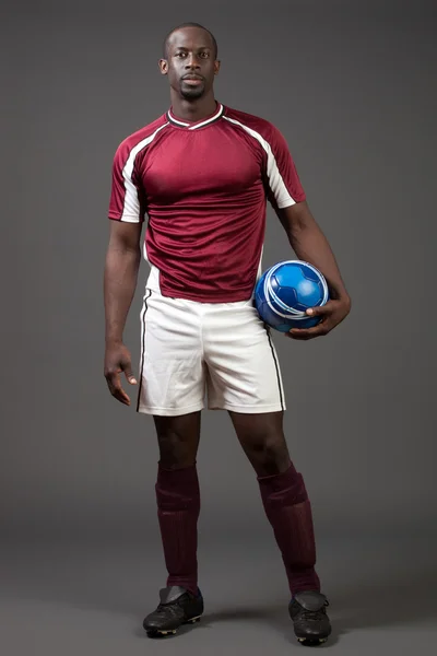 Jugador de fútbol masculino. Estudio filmado sobre gris . — Foto de Stock
