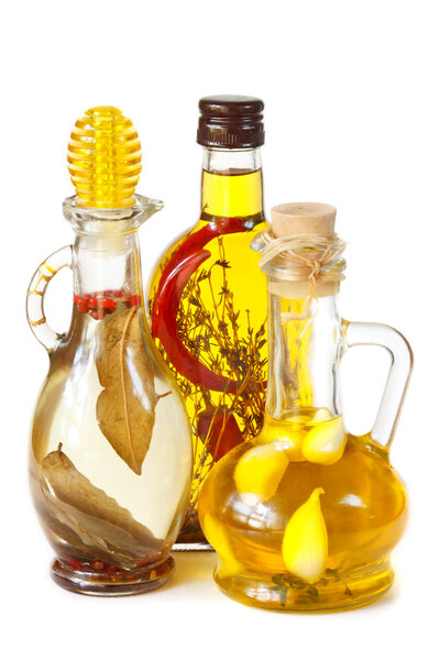 Spisy olive oil in a glass bottles with herbs for a salad.