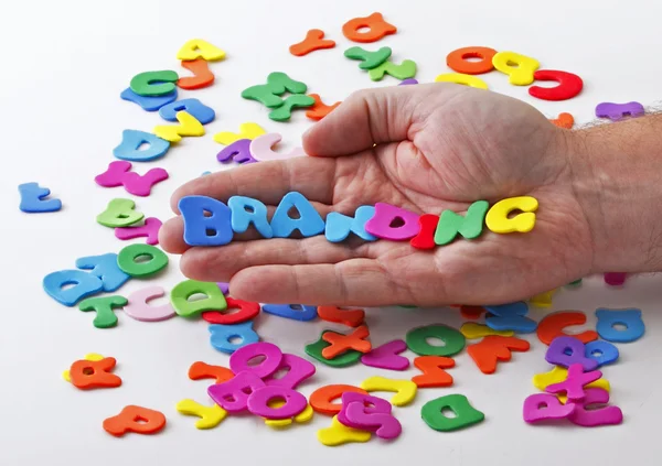 Hand houdt brieven branding — Stockfoto
