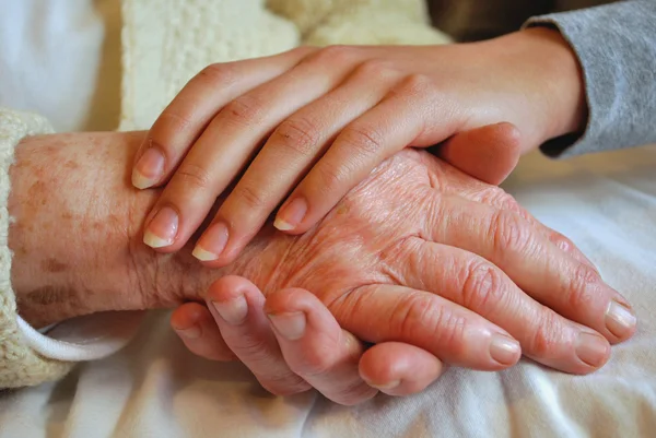 Zwei Generationen umarmen und Händchen halten - Großmutter Tochter Stockfoto