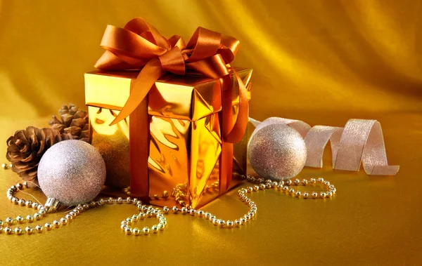 Christmas gift in gold box with bow — Stock Photo, Image