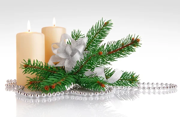 Hořící svíčka s větev firtree a stříbrný luk — Stock fotografie