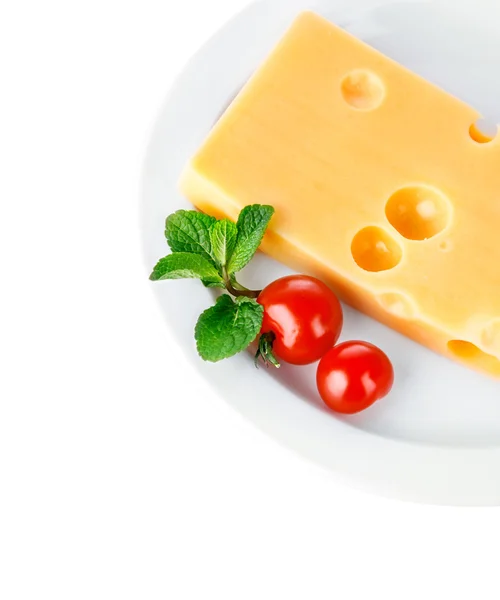 Yellow cheese in plate with tomatoes and leaf — Stock Photo, Image