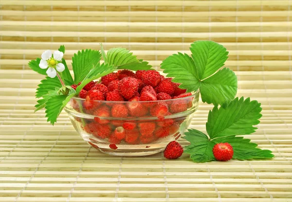 Folhas de frutas vermelhas morangos, com verde em vaso de vidro — Fotografia de Stock