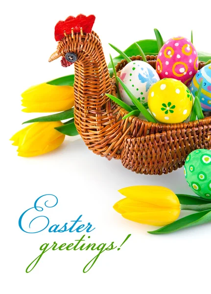 Huevos de Pascua en cesta con flores de tulipán amarillo — Foto de Stock