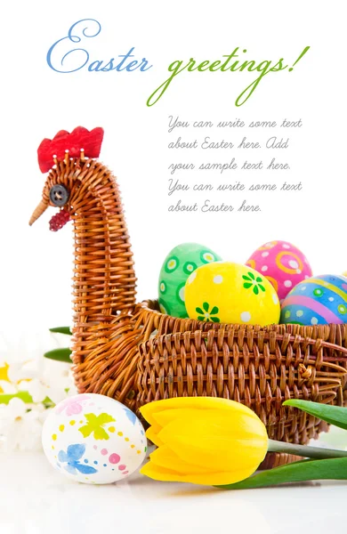 Huevos de Pascua en cesta con flores de tulipán amarillo — Foto de Stock